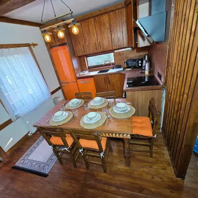 a kitchen with a wooden table with plates on it at Uludağ Tatil Evleri & Villa Şirin in Soğukpınar
