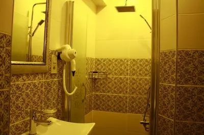 a bathroom with a shower and a sink and a mirror at Terra Suites in Istanbul