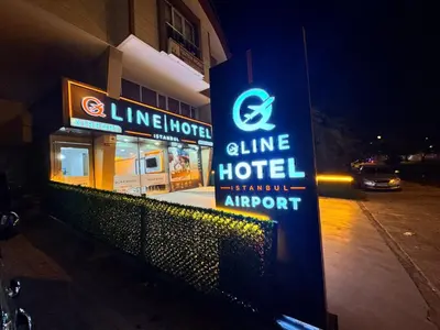 a sign for a line hotel on a street at night at QLİNE HOTEL AİRPORT SaW in Istanbul