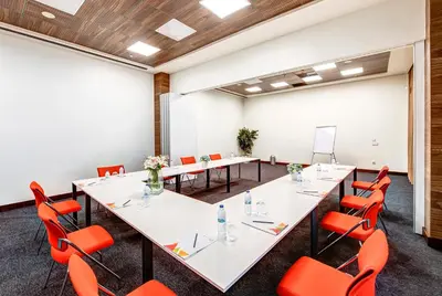 a conference room with white tables and orange chairs at The Elysium Styles Taksim in Istanbul