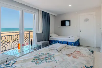 a bedroom with a bed and a balcony with the ocean at İstanbul Airport Holiday Beach Hotel in Arnavutköy