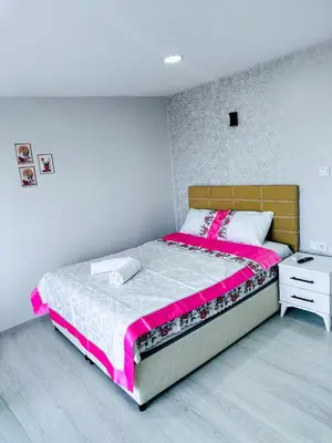 a bedroom with a bed with pink and white sheets at İstanbul Airport Holiday Beach Hotel in Arnavutköy