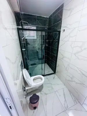 a bathroom with a toilet and a glass shower at İstanbul Airport Holiday Beach Hotel in Arnavutköy