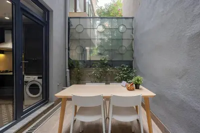a table and chairs sitting next to a wall at Amazing Luxury Duplex High Ceiling Patio! #403 in Istanbul