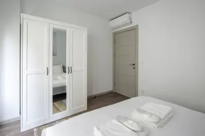 a white bedroom with a mirror and a bed at Amazing Luxury Duplex High Ceiling Patio! #403 in Istanbul