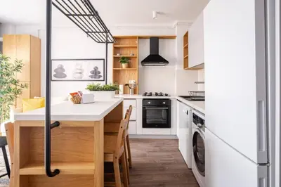 a kitchen with white cabinets and a table with chairs at Cozy Prime Location 1BD1Bath Sweet Home! #404 in Istanbul