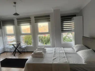 a bedroom with a bed and a table and windows at Mehmet Paşa Konağı in Istanbul