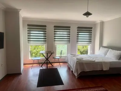 a bedroom with a bed and two windows with blinds at Mehmet Paşa Konağı in Istanbul