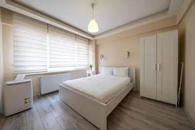 a bedroom with a large white bed and a window at White Rose Apart in Istanbul