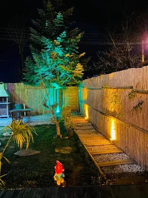 a backyard with a fence and a fire hydrant with lights at Bambu dağ evi in Sapanca