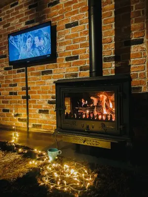 a fireplace with a television in a brick wall at Bambu dağ evi in Sapanca