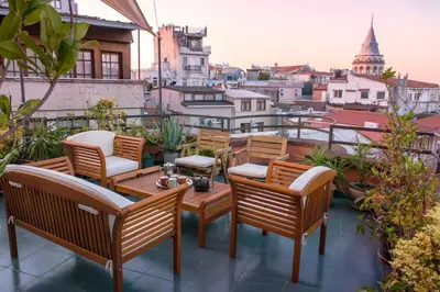 a patio with chairs and tables on a balcony at High Garden Rooftop Terrace Apartment Around Galata Tower in Istanbul