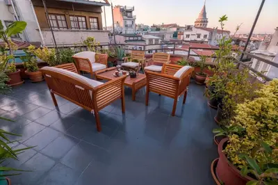 a patio with chairs and tables on a balcony at High Garden Rooftop Terrace Apartment Around Galata Tower in Istanbul
