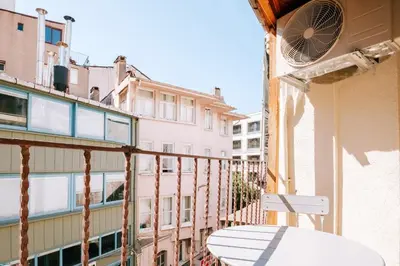 a balcony with a table and a fan on a building at Upscale Apartments w Balcony - Near Istiklal in Istanbul