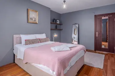 a bedroom with a large bed with a pink blanket at Duplex Flat w Panoramic Bosphorus View and Terrace in Istanbul