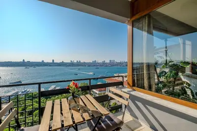 a balcony with a table and a view of the water at Duplex Flat w Panoramic Bosphorus View and Terrace in Istanbul