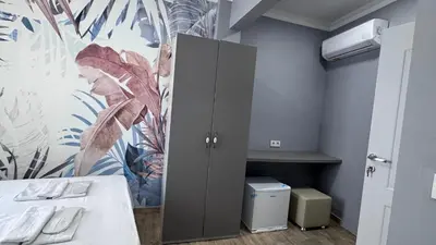 a room with a cabinet and a flower wallpaper at Matrushka Hotel Apart in Istanbul
