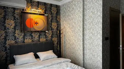 a bedroom with a bed and a tv on the wall at Tuzla Sahil Enjoy Hotel in Tuzla