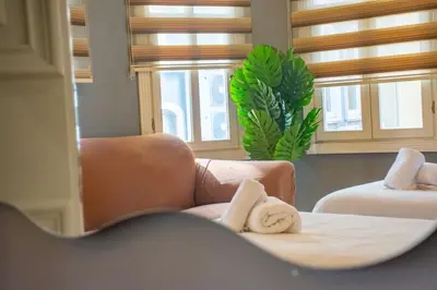 a room with a bed and a chair and windows at Modern 2BR Flat 1min walk to Taksim square in Istanbul