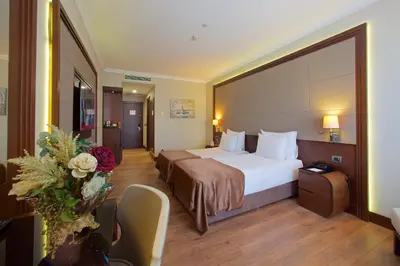 a hotel room with a bed and a table and chairs at Ramada by Wyndham Istanbul Merter in Istanbul