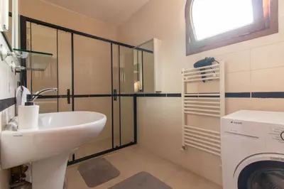 a bathroom with a sink and a washing machine at 4BR all AC Pool BBQ Garden on Bagdat Ave Kirkpinar in Sapanca