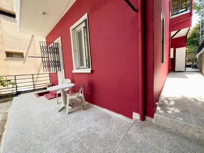a red building with a table and chairs on a patio at Garden House Heybeliada in Adalar