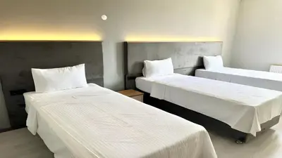 a room with two beds with white sheets at Altınova Hotel Sakarya in Serdivan