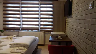 a bedroom with two beds and a table and a window at Hotel Kiwi in Istanbul