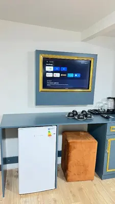 a kitchen with a table with a tv on the wall at crown taksim hotel in Istanbul