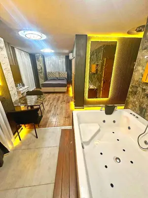 a large bathroom with a tub and a living room at Taksim Luxury Arcadia Hotel in Istanbul