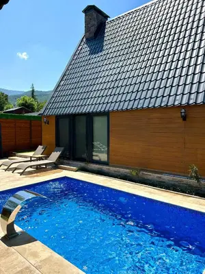 a swimming pool in front of a house at Finymoco in Kartepe
