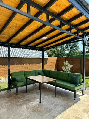 a pergola with a green couch and a table at Finymoco in Kartepe