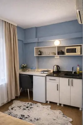 a kitchen with white cabinets and a blue wall at Casafra in Istanbul
