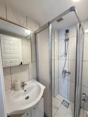 a white bathroom with a sink and a shower at Casafra in Istanbul