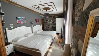 a bedroom with two beds and a brick wall at La Fontaine Otel in Mudanya