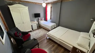 a small room with a bed and a chair at La Fontaine Otel in Mudanya