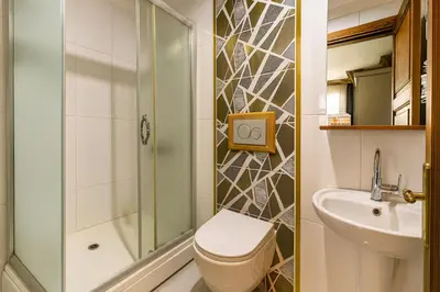 a bathroom with a shower and a toilet and a sink at La Fontaine Otel in Mudanya