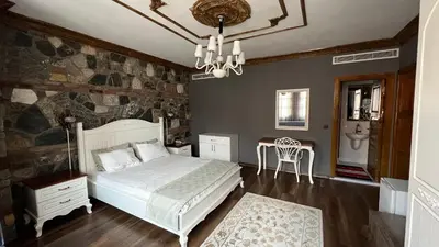 a bedroom with a bed and a chandelier at La Fontaine Otel in Mudanya