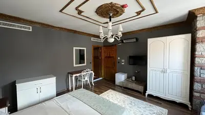 a bedroom with a bed and a chandelier at La Fontaine Otel in Mudanya