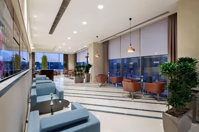 a lobby with blue chairs and tables and windows at Hilton Garden Inn Istanbul Beylikduzu in Istanbul