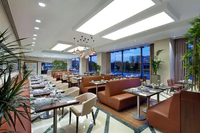 a restaurant with tables and chairs and windows at Hilton Garden Inn Istanbul Beylikduzu in Istanbul