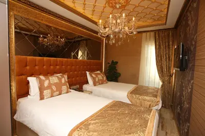 a bedroom with two beds and a chandelier at Laleli Blue Marmaray Hotel in Istanbul