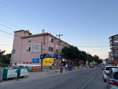 a pink building on the side of a city street at Kumbağ Otel in Kumbağ