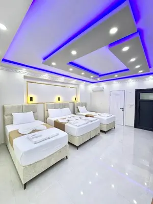 three beds in a room with purple lighting at Hagia Sophia Palace Hotel in Istanbul