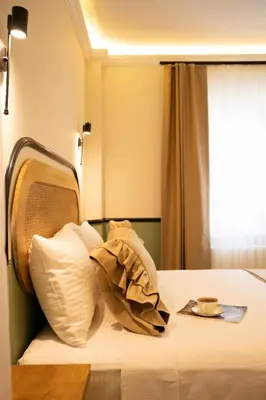 a bed with white pillows and a cup on it at Hotel Zon in Serdivan