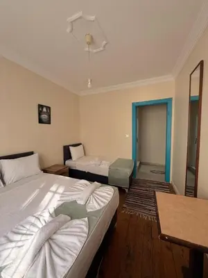 a bedroom with two beds and a table and a mirror at walkabout apart in Istanbul