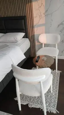 two white chairs and a table next to a bed at Dap Vazo Kule Rezidansta Konaklama Hizmeti in Istanbul