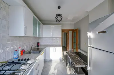 a kitchen with white cabinets and a white refrigerator at Par Konaklama in Istanbul