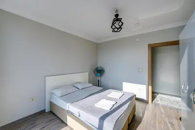 a white bedroom with a bed and a bathroom at Par Konaklama in Istanbul