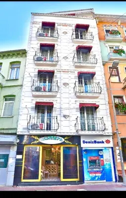 a tall white building with balconies on a city street at Santefe Hotel in Istanbul
